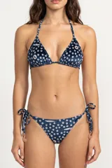 Top de bikini triangular con tiras para anudar al cuello y la espalda, confeccionado en tela con estampado geométrico de círculos sobre base azul.