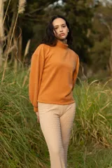 Buzo color naranja con cuello alto y mangas abullonadas.