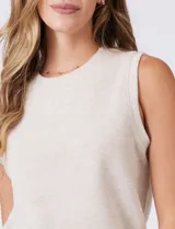 Buzo sin mangas color beige, de tejido melange suave, con cuello a la base y sisas amplias. Presenta pequeños tajos en el ruedo para una mejor caída.