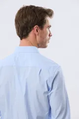 Camisa de vestir celeste rayada de manga larga, con cuello camisero, bolsillo ojal en el pecho y cierre frontal con botones.