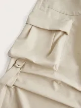 Pantalón cargo color crema de corte baggy, con múltiples bolsillos en los laterales y aberturas en los tobillos.