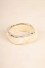 Set de dos pulseras rígidas con forma cuadrada, una color crema con efecto marmolado y otra plateada.