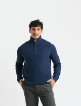 Sweater de punto inglés color verde, con cuello alto y cierre frontal parcial metálico. Diseño de manga larga con puños y ruedo acanalados.