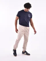 Pantalón tipo jogger de gabardina, con cintura elástica ajustable mediante cordón y puños elásticos en los tobillos.