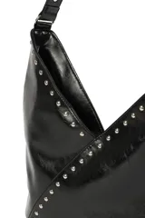 Cartera tipo hobo de cuero sintético negro con acabado brillante, decorada con tachuelas metálicas plateadas a lo largo de la correa y en la costura frontal diagonal.