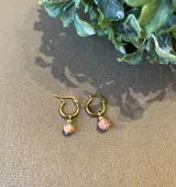 Aros de argolla dorada con dije redondo de fimo color naranja con estampado floral y bolita dorada.