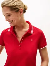 Chomba roja de corte slim confeccionada en algodón elástico, con cuello y mangas ribeteadas en blanco, tapeta de cinco botones y logo bordado en el pecho.