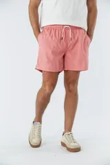 Short de baño liso color salmón, con cintura elástica ajustable mediante cordón, dos bolsillos laterales y un bolsillo posterior.