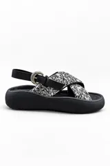 Sandalias de plataforma color negro, con tiras cruzadas de tela estampada en blanco y negro, tira trasera ajustable con hebilla metálica y suela chunky de goma.