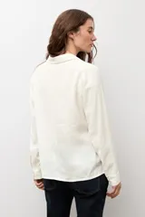Camisa clásica de manga larga, color azul marino, con cuello camisero y cierre frontal de botones.