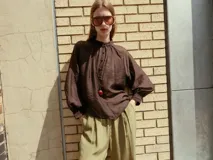 Blusa de cuello subido y manga larga abullonada con puños ajustados. Presenta un diseño semitransparente con textura arrugada y cierre frontal con botones a tono.