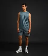 Bermuda deportiva masculina de color gris azulado, confeccionada en tejido técnico con textura perforada. Presenta cintura elástica con cordón de ajuste y diseño funcional para entrenamiento.