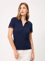 Remera polo azul marino de manga corta, con cuello en V sin botones y ribetes tricolores en el cuello y los puños.