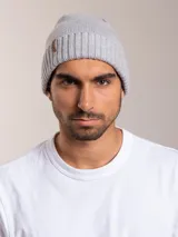 Gorro de lana azul con etiqueta de cuero sintético con logo de la marca en el frente.