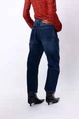 Jean slouch de tiro medio, color azul oscuro, con costuras decorativas en las piernas y diseño de paneles.