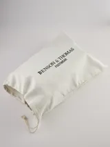 Bota Chelsea de gamuza gris con elásticos laterales, suela de goma marrón y tirador trasero.