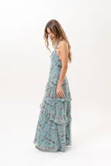 Vestido largo celeste con estampado abstracto en tonos marrones, escote halter con abertura en el frente y volados escalonados en la falda.