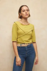 Remera negra de manga tres cuartos, escote redondo y detalle de costuras superpuestas de forma asimétrica.