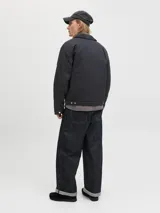 Campera estilo worker de color negro, con cuello camisero, cierre frontal con cremallera y bolsillos laterales. Presenta un diseño minimalista y funcional con acabado limpio.