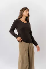 Remera de manga larga color beige, con escote redondo levemente abierto y calce regular. Confeccionada en tejido suave, liviano y con leve elasticidad.