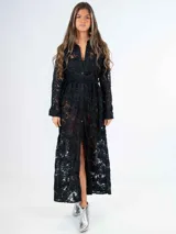 Vestido largo de encaje negro con cuello camisero, abotonado al frente y con cinturón de lazo.