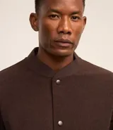 Campera bomber azul marino de pana con cuello redondo, cierre con botones a presión, bolsillos laterales y puños y cintura elastizados.