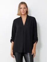 Blusa de tejido piqué con textura, marca Floral & Ivy. Presenta escote en V con pliegue central delantero, mangas tres cuartos con presilla y botón para regular el largo, y tajos en los laterales.