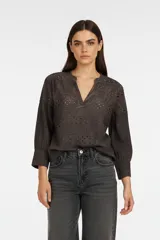 Blusa de algodón con diseño de broderie, cuello en V y mangas 3/4 con puños.