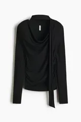 Remera negra de manga larga en punto suave, con ajuste entallado, cuello drapeado con tiras anchas estilo fular y laterales fruncidos.