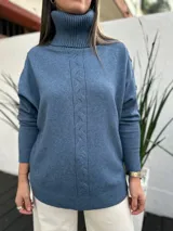 Polerón de cuello alto en tejido de punto color azul jean, con diseño de trenza central vertical y puños acanalados.