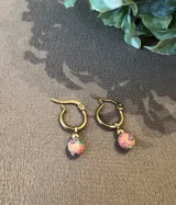 Aros de argolla dorada con dije redondo de fimo color naranja con estampado floral y bolita dorada.