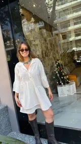 Vestido corto blanco con bordado calado, corte holgado, cuello camisero y mangas 3/4 con volados.