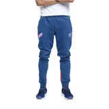 Pantalón de jogging azul con puños ajustados, cintura elástica con cordón de ajuste y bolsillos laterales. Presenta el escudo del Club Nacional de Football en el muslo izquierdo y el logo de Umbro en el muslo derecho. Tiene una franja vertical roja en la parte inferior de cada pierna.