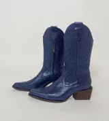 Bota tejana de cuero azul con diseño calado y detalles bordados. Tiene un taco de madera de 5cm y cierre lateral.
