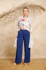 Pantalón de vestir azul eléctrico, de corte palazzo y tiro alto, con pinzas en la cintura y bolsillos laterales.