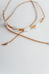 Gargantilla de cuero marrón con dije de estrellas espejadas.