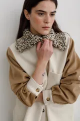 Camisa de paño de lana, color negro, con cuello tejido en contraste y cierre frontal de botones claros. Presenta bolsillos frontales y diseño de corte recto.