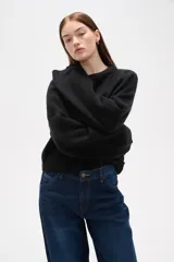 Sweater de tejido de punto color negro, con cuello redondo a la base, mangas largas y diseño holgado.