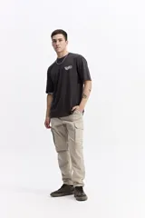 Remera de manga corta color crema con cuello redondo y fit regular. Presenta un estampado grande en la espalda con una flor estilizada en tonos rojo y azul, y texto que incluye "WE ALL GROW" y "trust the process, great things take time".