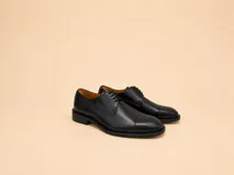 Zapato de vestir tipo oxford de cuero negro con puntera reforzada y cordones al tono.