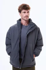 Campera puffer negra de corte estándar, con cuello alto, cierre frontal completo y puños elásticos.