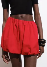 Short de gabardina color rojo con diseño abuchonado estilo globo, cintura elástica y bolsillos laterales.