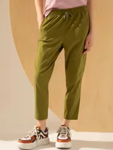 Pantalón babucha color verde oliva, tiro alto, largo arriba del tobillo, con cintura elástica ajustable con cordón y bolsillos laterales.