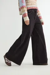 Jean de corte wide leg con diseño de costuras verticales decorativas en el frente, tiro medio y cierre frontal con botón y cremallera.