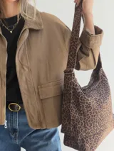 Bolso tipo hobo con estampado animal print y acabado efecto gamuza. Cuenta con asa regulable y cierre superior con cremallera.