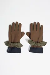 Guantes de diseño patchwork en tonos marrón, verde oliva y azul marino, con detalle de lazo decorativo en la muñeca.