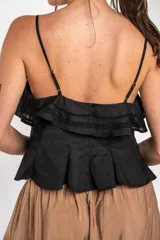 Top negro de 100% algodón, con tirantes finos, escote recto y volados dobles con detalles de encaje en el frente.