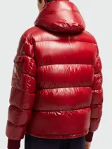 Campera puffer Moncler modelo Maljasset, de color rojo brillante, con capucha integrada, cierre frontal con botones a presión, bolsillos laterales con cierre y bolsillo pequeño en la manga con logo de la marca.