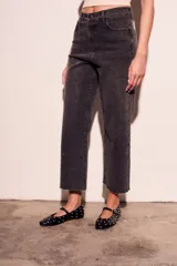 Pantalón de jean negro con efecto gastado y pequeños brillos. Corte recto, tiro alto y terminación desflecada.