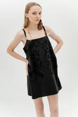 Vestido corto color marrón, con breteles finos, escote recto y bordado floral en el frente.